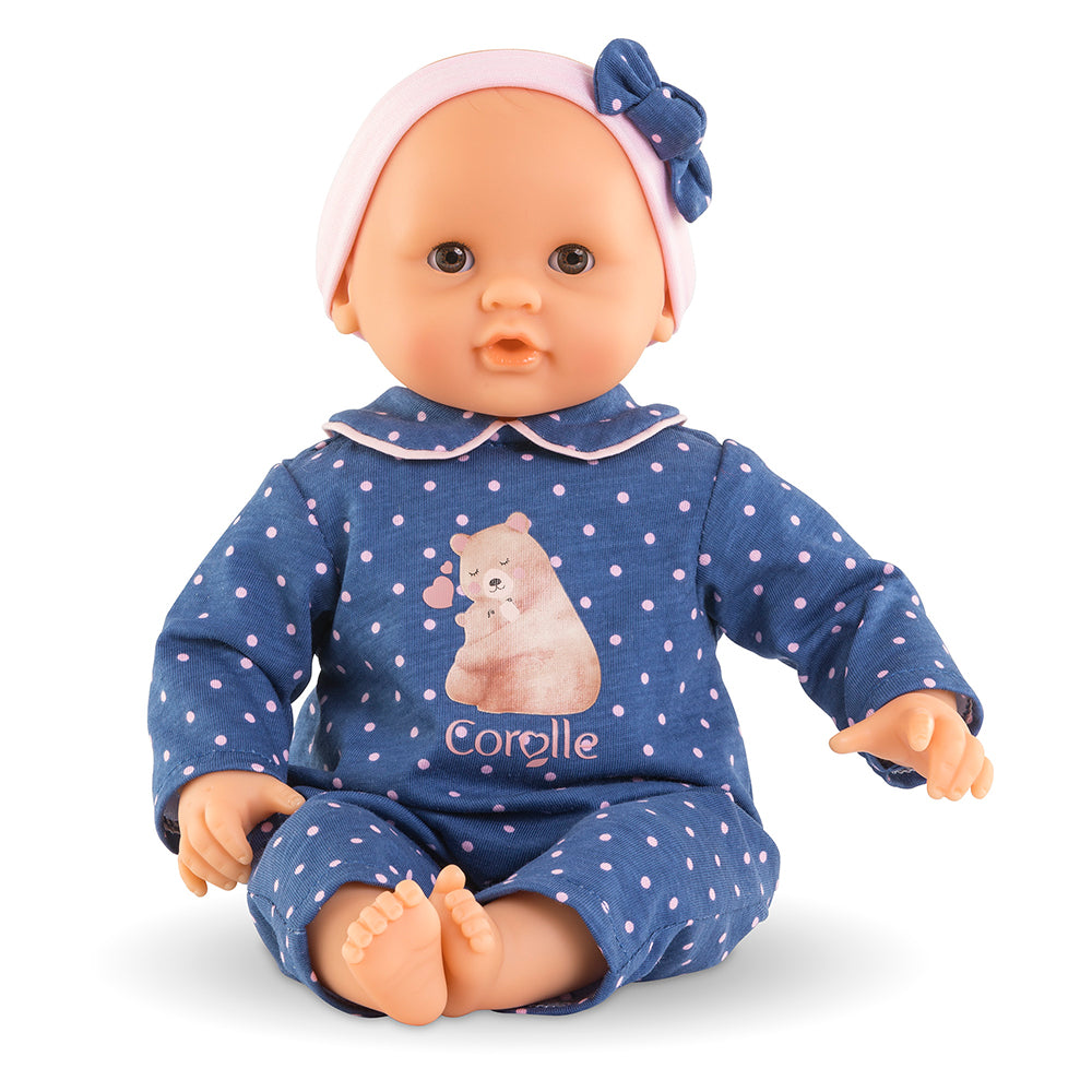 poupon Bébé Calin Capucine en vêtements à pois de Corolle, assis, avec un bandeau rose.