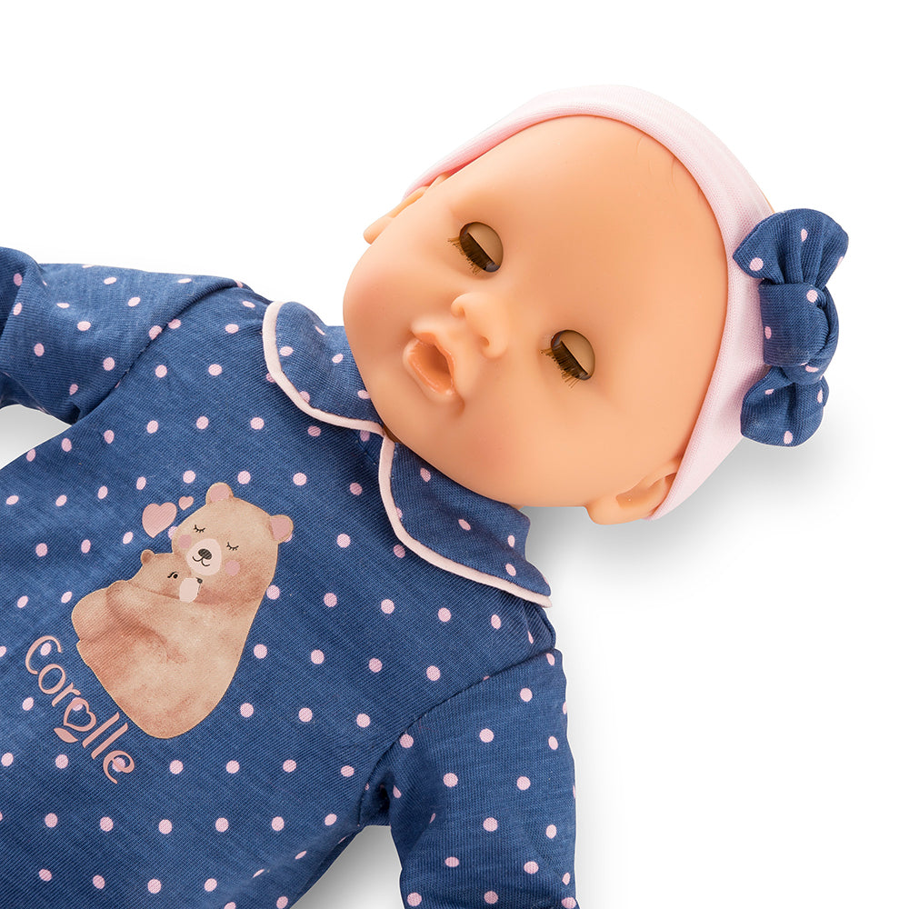 Image du poupon Bébé Calin Capucine de Corolle, 30 cm, vêtu d'un pyjama à pois avec un motif d'ours.