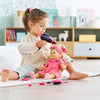 Une enfant joue avec le coffret coiffure Corolle, coiffant une poupée avec un peigne et un sèche-cheveux.