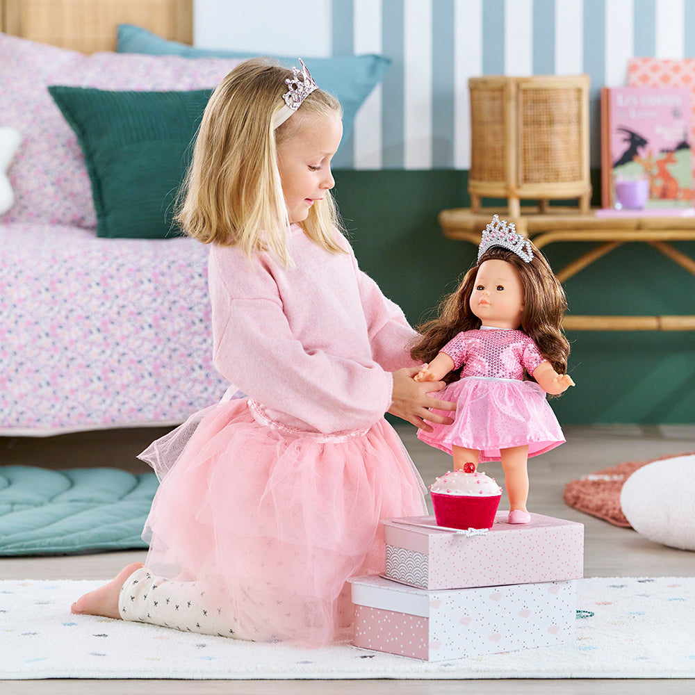 Fille joyeuse jouant avec le coffret princesse anniversaire poupée Corolle, habillée en tutu rose.