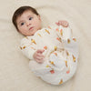 Dormeuse imprimé cornets de crème glacée portée par un bébé sur une couverture beige.