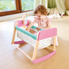 Une fille joue avec un berceau en bois pour poupée Sweet Dreams, berceau en bois pour poupée coloré en rose.