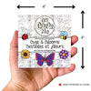 Mini livre de coloriage Bestioles et fleurs présenté dans une main, avec dessins de fleurs et insectes.