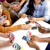 joueurs de société jouant à jeu de société UNO Party autour d'une table, cartes en main, ambiance festive