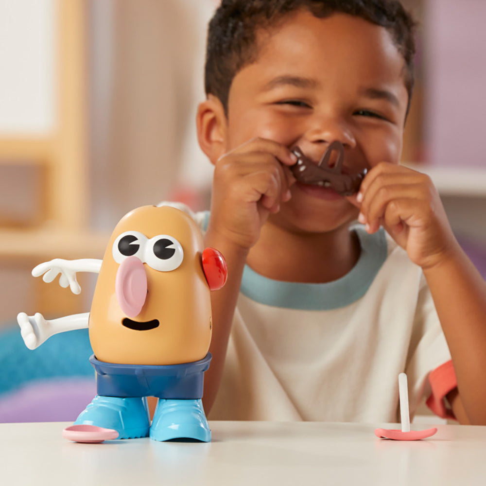 Un enfant s'amusant avec le jouet Monsieur Patate, créant des visages rigolos avec des accessoires colorés.