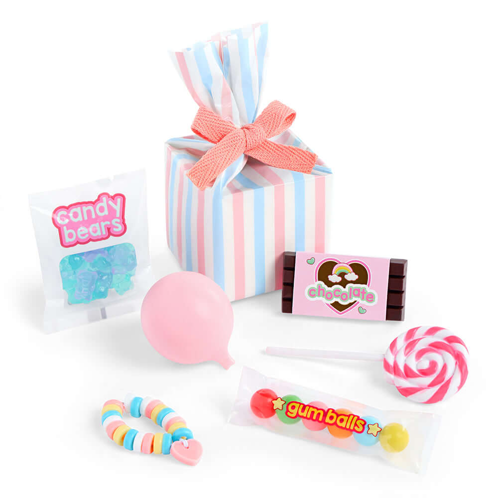 Poupée Kat Our Generation avec des bonbons colorés, y compris des gommes, des sucettes et un paquet-cadeau.