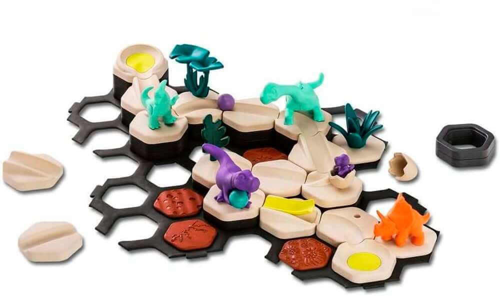 GraviTrax Junior dinosaure starter set avec des figurines de dinosaures colorés sur des bases en forme de tuiles.