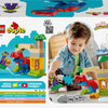Jeune enfant jouant avec le Lego Duplo Spidey-Rex contre le Bouffon vert, mettant en avant l'imagination et la créativité.