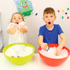 Enfants amusés jouant avec des boules de neige artificielles Zimpli dans des bols colorés.