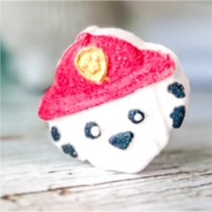 Bombe de bain Chookie en forme de pompier avec un chapeau rouge et des motifs noirs.