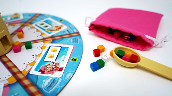 jeu coopératif Cakozaurus avec planche de jeu et jetons colorés.