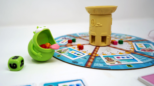jeu coopératif Cakozaurus avec un monstre croque-gâteau et un plateau coloré.