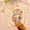 Broderie de perlage haute couture sur un tambour en tissu avec des motifs floraux colorés.