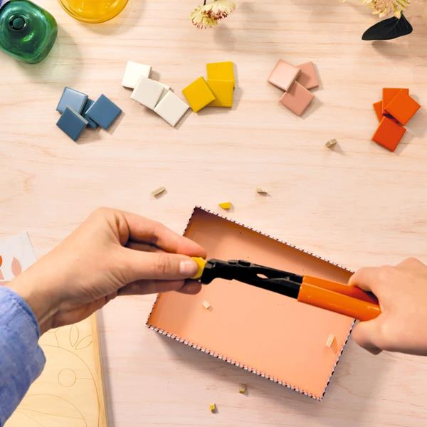 Initiation mosaïque libellule : mains utilisant une pince pour créer des mosaïques colorées.