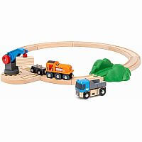 Coffret de démarrage BRIO avec train, camion, voie ferrée et grue, préparant l'aventure ferroviaire.