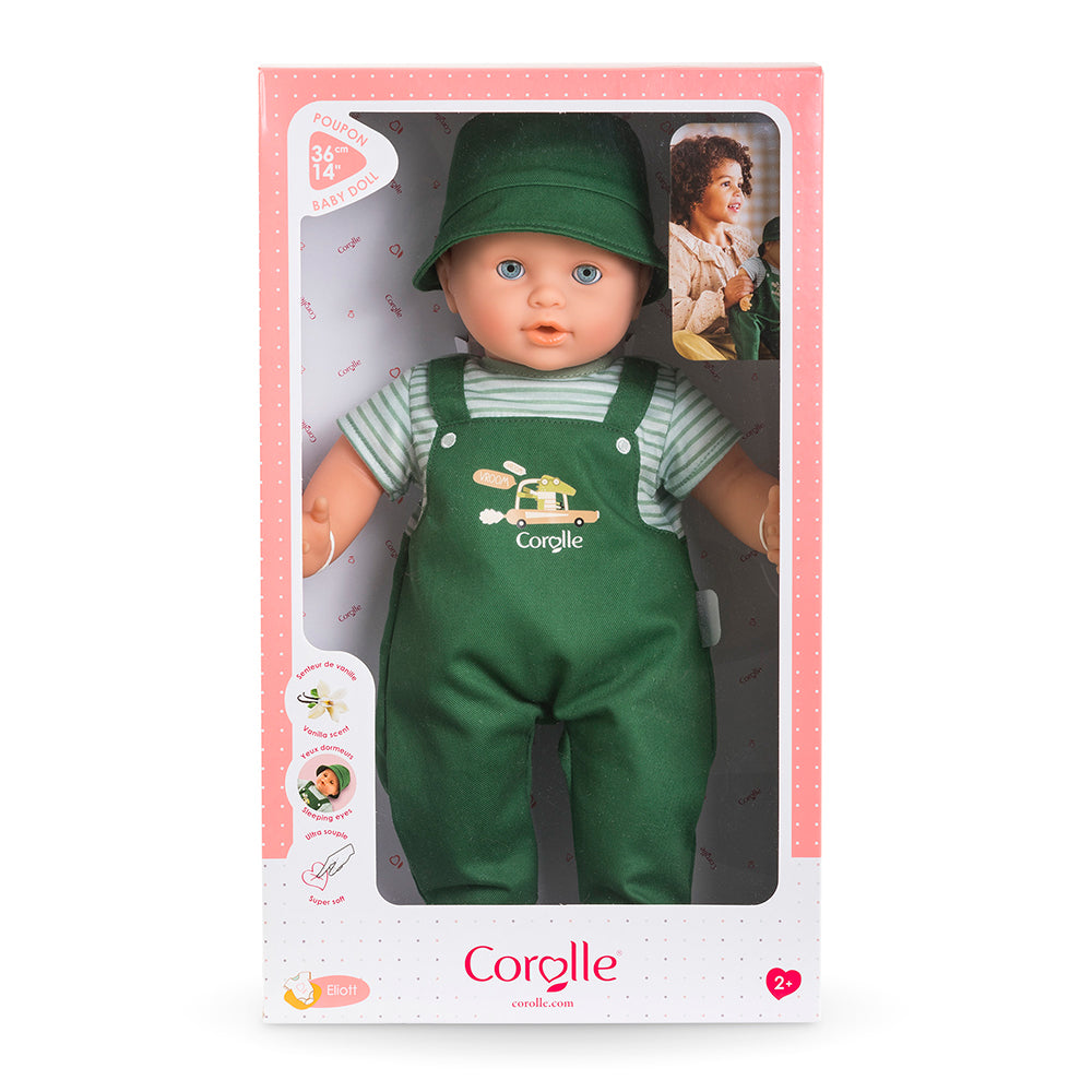grand poupon Corolle Eliott 36 cm dans sa boîte avec une tenue verte et un chapeau.