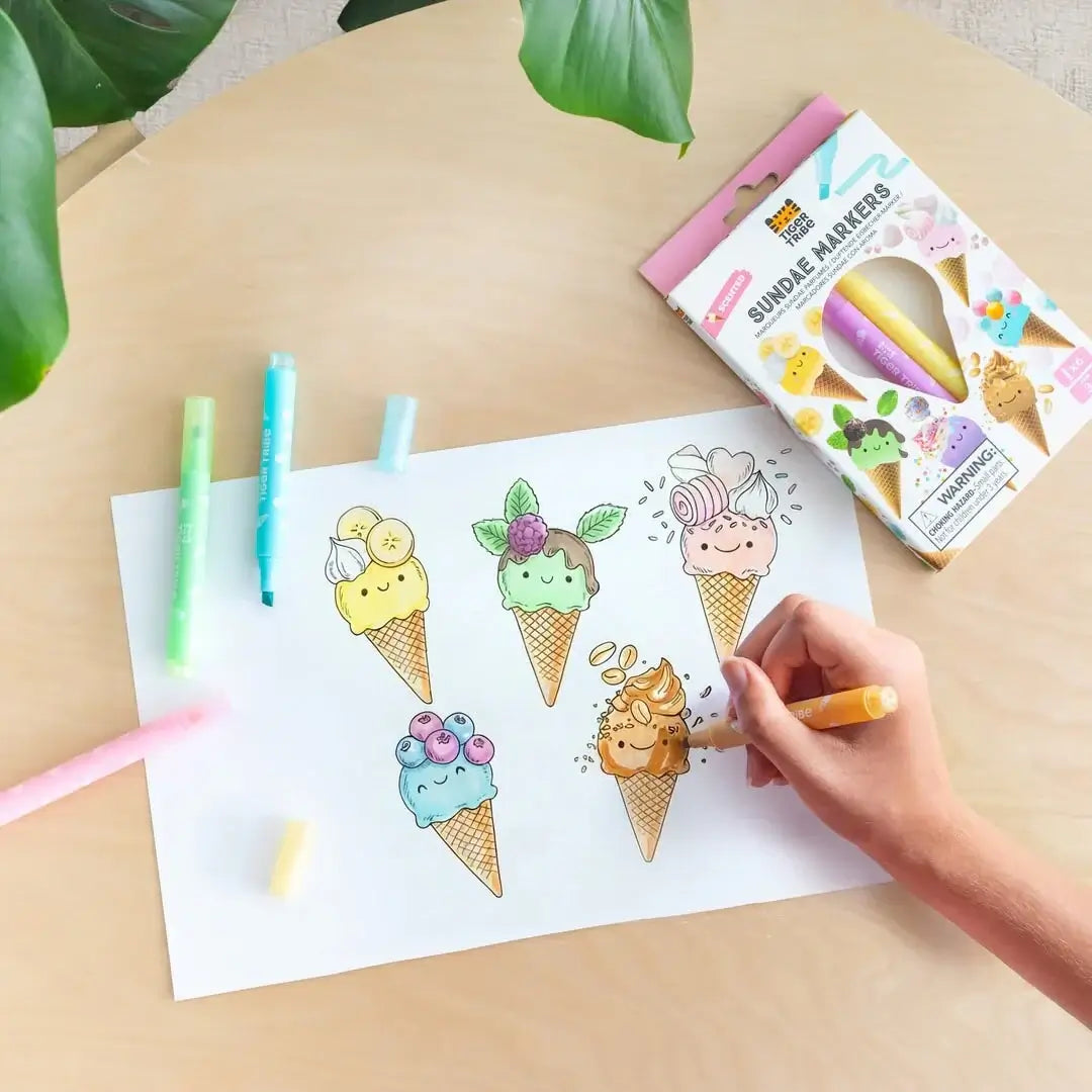 Enfant coloriant un dessin de glaces avec des feutres parfumés gourmands de Tiger Tribe.